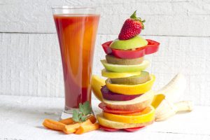 Smoothie made with fruit and vegetables plus a pile of fruit